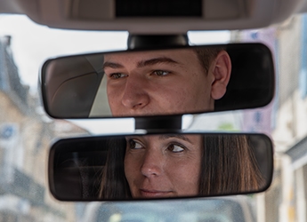 les regards d'un élève et de sa monitrice dans le double rétroviseur d'une voiture d'auto-école à Saint-cyprien 24.